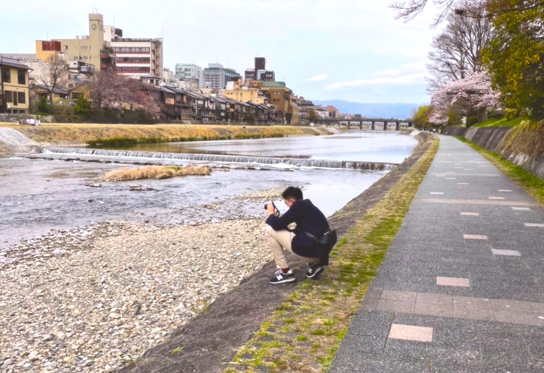 Koji Murata, an experienced app developer taking photo by the riverbank in Kyoto Japan